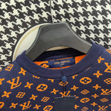 Flat lay presentation of Louis Vuitton luxury clothing with label-forward styling