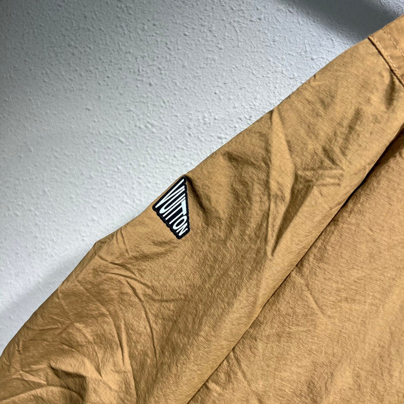 Flat lay presentation of Louis Vuitton luxury clothing with label-forward styling