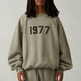 Fear of God Essentials Sweatshirt flat lay on neutral background
