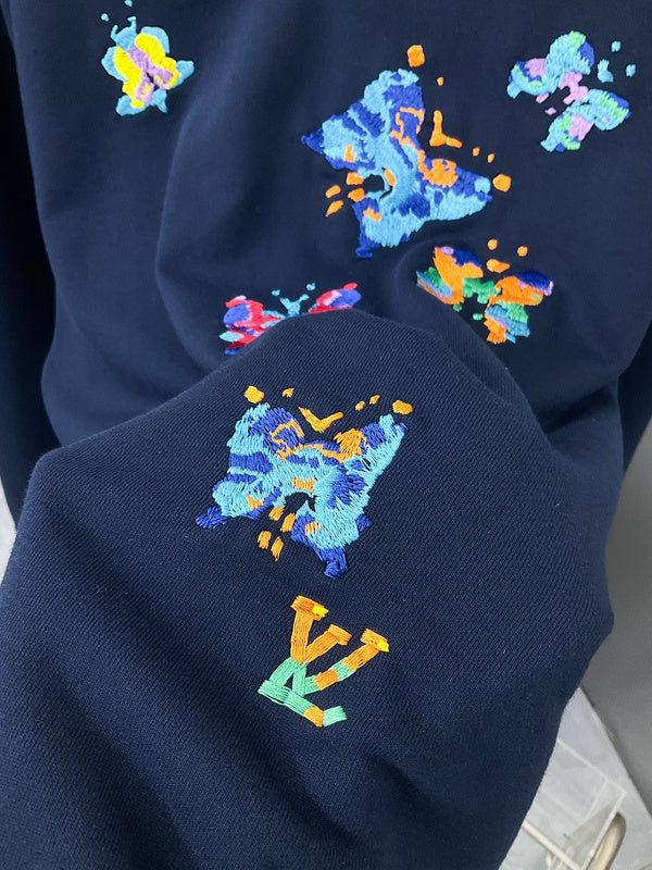 Flat lay presentation of Louis Vuitton luxury clothing with label-forward styling