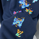 Flat lay presentation of Louis Vuitton luxury clothing with label-forward styling