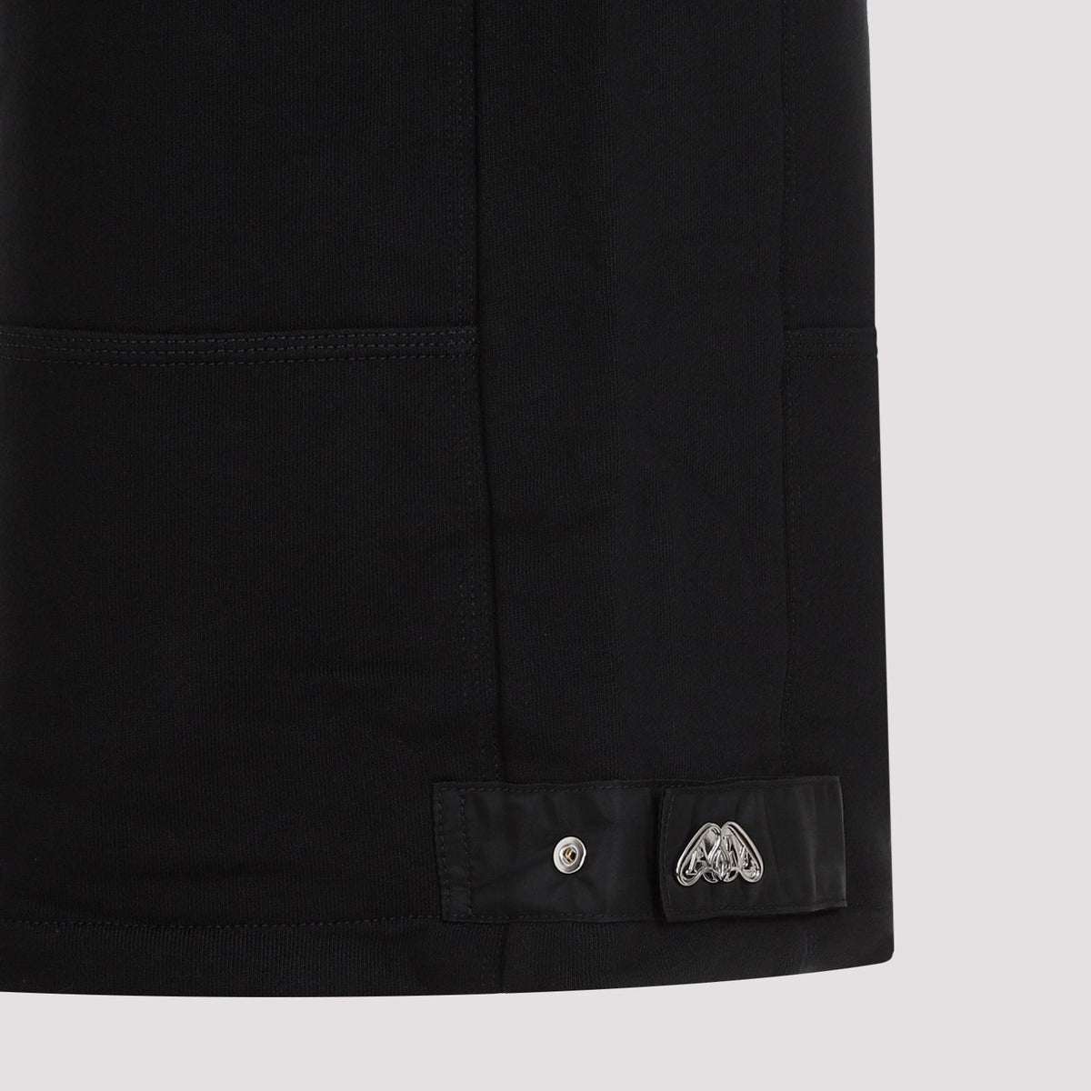 Close-up of Alexander McQueen pants hardware and fine stitching