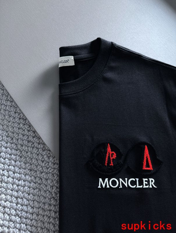Flat lay presentation of Moncler luxury clothing with signature branding