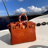 Signature top-handle bag carried on shoulder