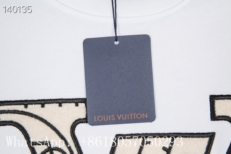 Flat lay presentation of Louis Vuitton luxury clothing with label-forward styling