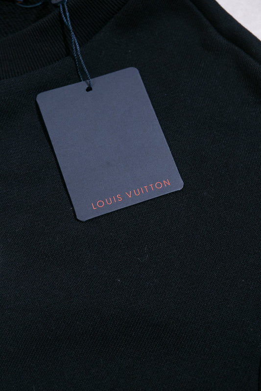 Flat lay presentation of Louis Vuitton luxury clothing with label-forward styling