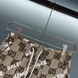 Flat lay presentation of Gucci luxury clothing with monogram-inspired silhouette