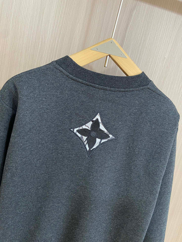 Flat lay presentation of Louis Vuitton luxury clothing with label-forward styling