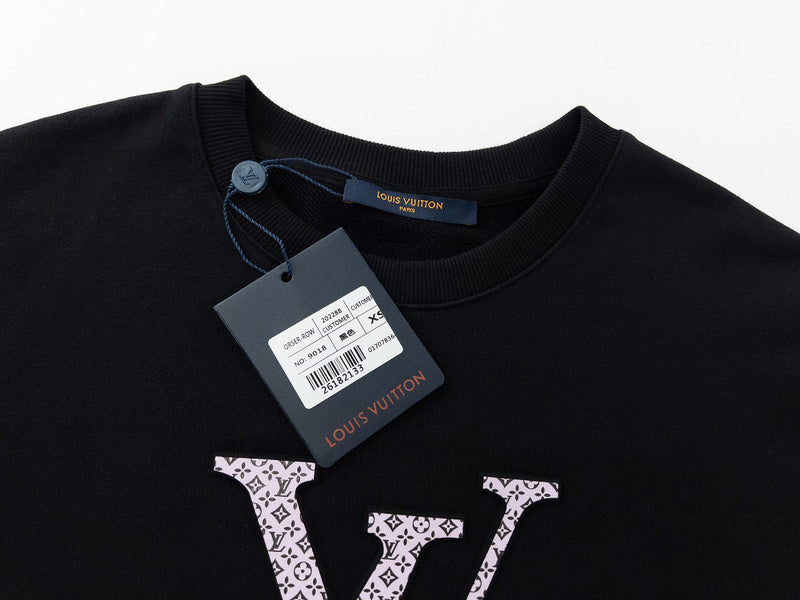 Flat lay presentation of Louis Vuitton luxury clothing with signature branding