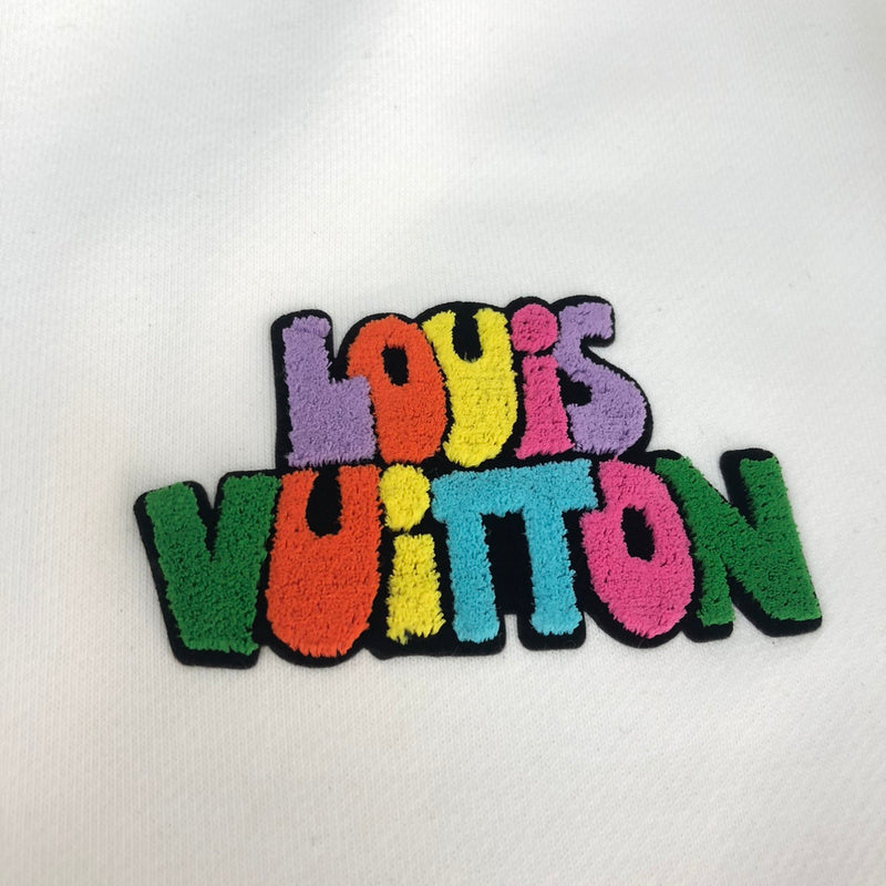 Flat lay presentation of Louis Vuitton luxury clothing with signature branding
