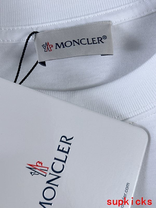 Flat lay presentation of Moncler luxury clothing with signature branding