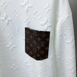 Flat lay presentation of Louis Vuitton luxury clothing with label-forward styling