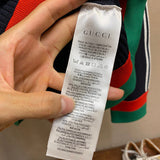 Side profile of Gucci luxury clothing with label-forward styling