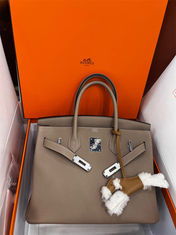  Understated top-handle bag carried on shoulder