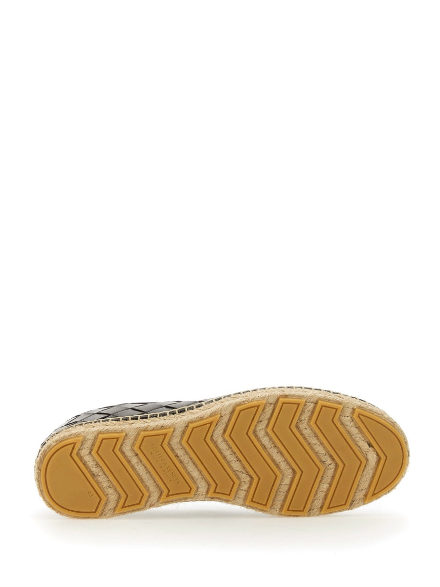 Close-up of Bottega Veneta slides hardware and fine stitching
