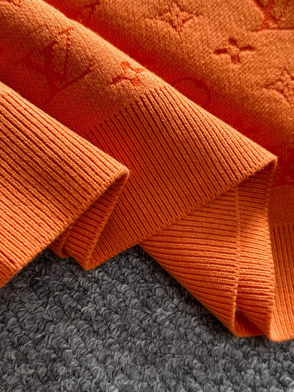 Flat lay presentation of Louis Vuitton luxury clothing with label-forward styling