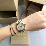 Close-up detail view of Burberry women's gold watch