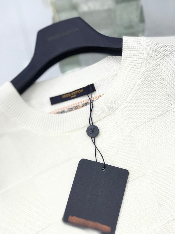 Flat lay presentation of Louis Vuitton luxury clothing with signature branding