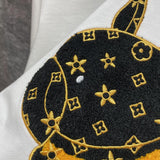 Flat lay presentation of Louis Vuitton luxury clothing with label-forward styling