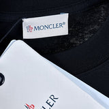 Flat lay presentation of Moncler luxury clothing with signature branding