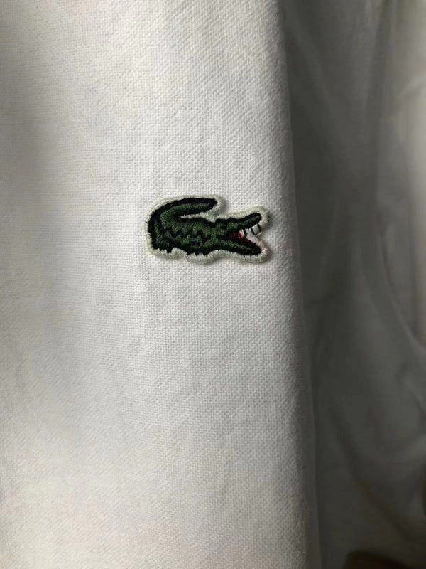 Flat lay presentation of Lacoste luxury clothing with monogram-inspired silhouette