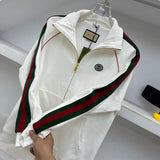 Flat lay presentation of Gucci luxury clothing with label-forward styling