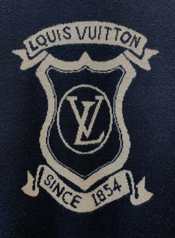Flat lay presentation of Louis Vuitton luxury clothing with label-forward styling