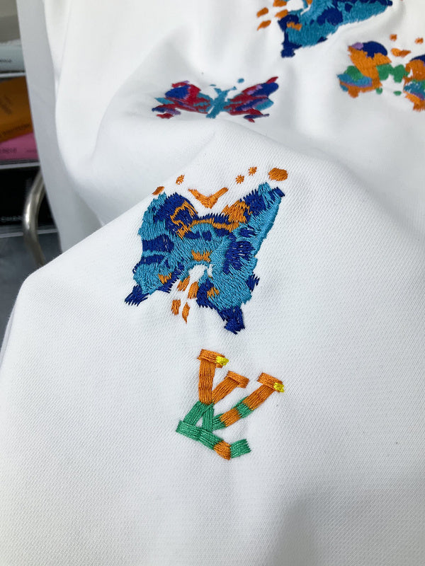 Flat lay presentation of Louis Vuitton luxury clothing with label-forward styling