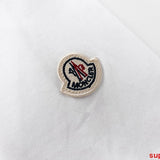 Flat lay presentation of Moncler luxury clothing with monogram-inspired silhouette