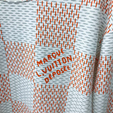 Flat lay presentation of Louis Vuitton luxury clothing with label-forward styling