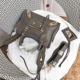 Handle and strap detail of polished structured women's handbag – women's designer-style accessory