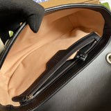 Side profile of polished signature women's handbag – women's luxury accessory