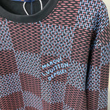 Flat lay presentation of Louis Vuitton luxury clothing with label-forward styling
