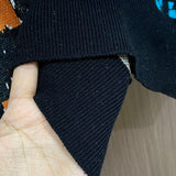 Close-up detail shot of Louis Vuitton luxury clothing with logo-detail design