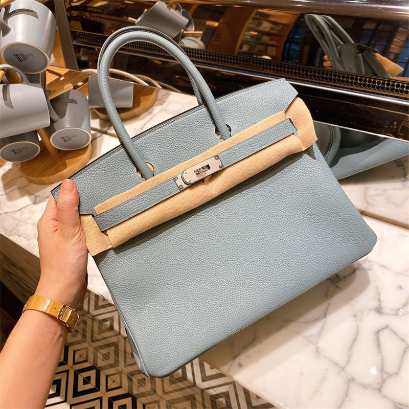  Sophisticated top-handle bag carried on shoulder