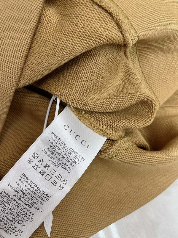 Flat lay presentation of Gucci luxury clothing with monogram-inspired silhouette